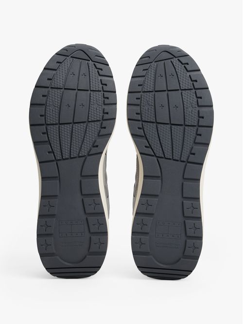 Tenis gris con texturas mixtas y logo