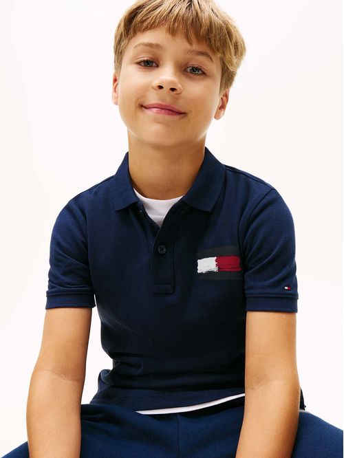 Polo azul con bandera bordada en el pecho